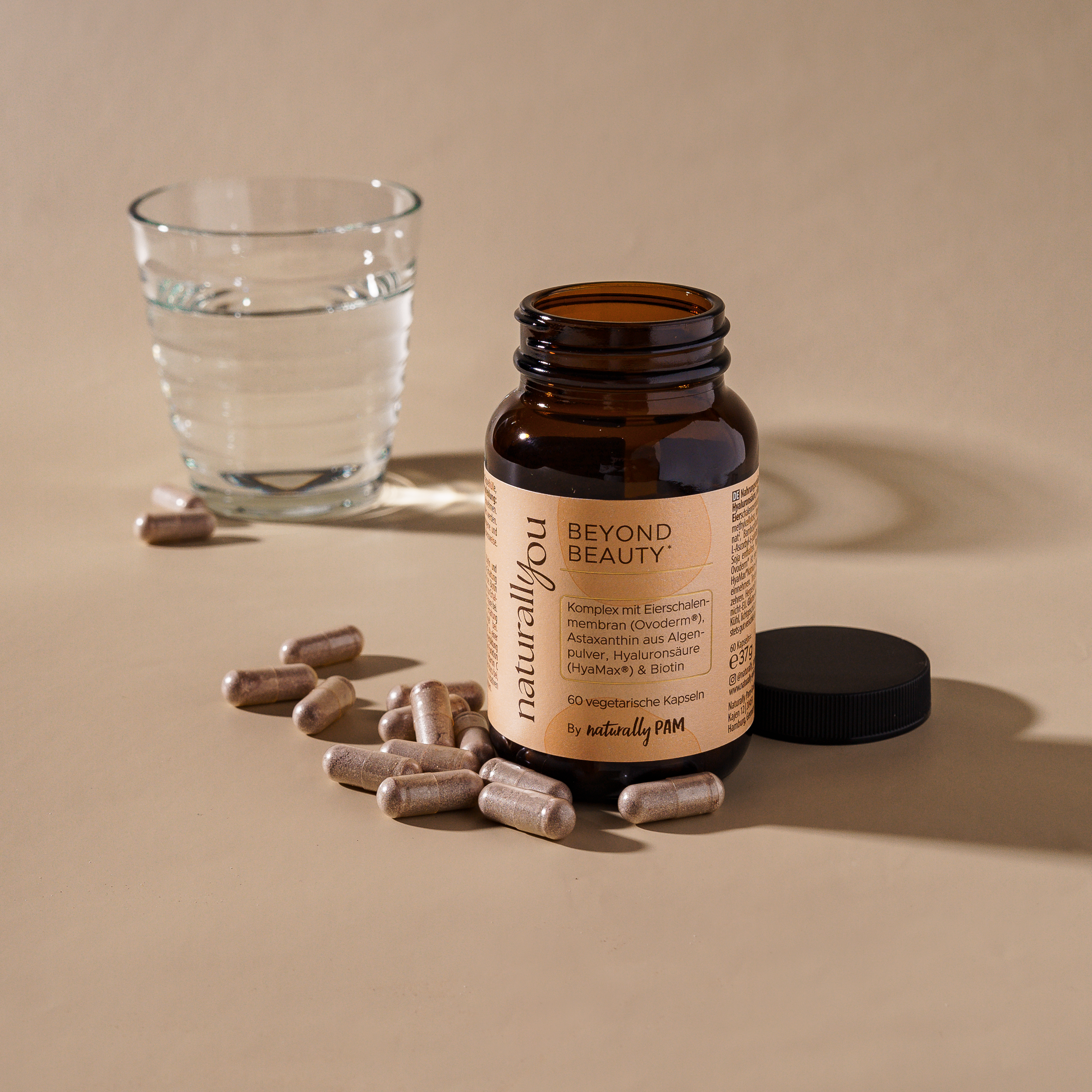 Natürliches Nahrungsergänzungsmittel Naturally You Beyond Beauty von Naturally Pam, Flasche mit weißen Kapseln auf weißem Hintergrund